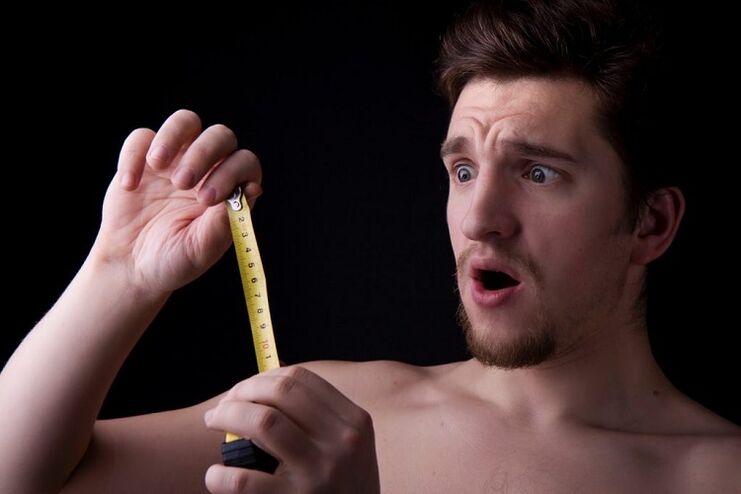 A man uses a tape measure to measure his penis before enlargement surgery